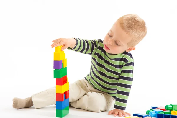 Weinig schattige jongen spelen met bouwstenen. geïsoleerd op wit. — Stockfoto