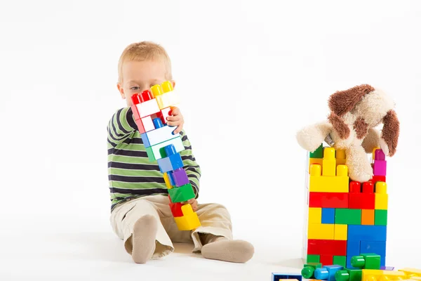 Menino bonito brincando com blocos de construção. Isolado em branco . — Fotografia de Stock