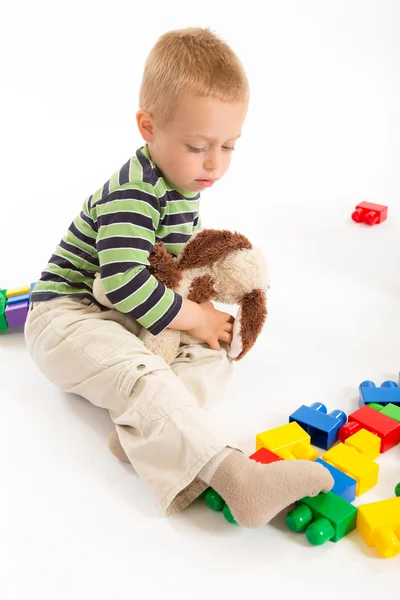 Pequeño chico lindo jugando con bloques de construcción. Aislado sobre blanco . —  Fotos de Stock