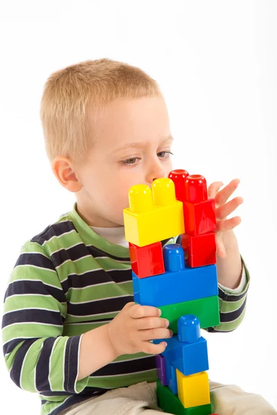 Little cute boy playing with building blocks. Isolated on white. — Stock Photo, Image