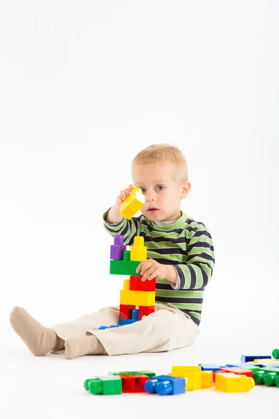 Menino bonito brincando com blocos de construção. Isolado em branco . — Fotografia de Stock