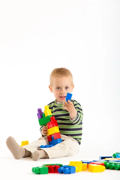 Weinig schattige jongen spelen met bouwstenen. geïsoleerd op wit. Stockfoto