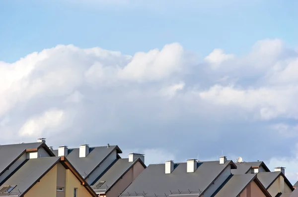 Střechy řadového domku, panorama střešní byt a světlé letní cloudscape — Stock fotografie