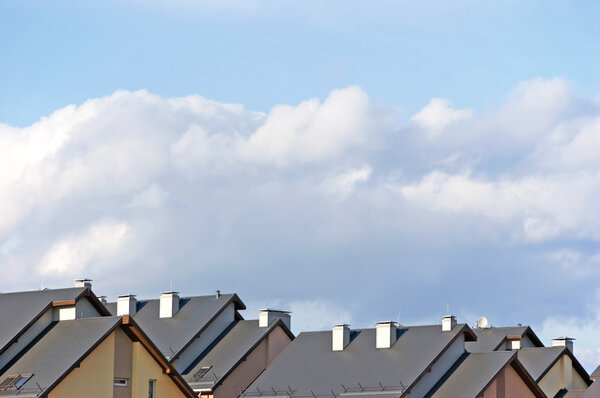 Row house roofs, condo rooftop panorama and bright summer cloudscape