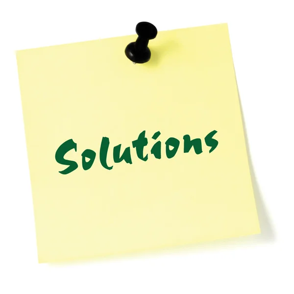 Solutions, written on a sticky adhesive note, isolated yellow post-it style sticker, black thumbtack pushpin, green text — Stock Photo, Image