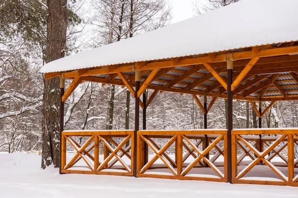 冬に雪に覆われたコテージ村で屋外でリラックスする場所 降雪後の曇りの冬の日に木製の展望台 季節の詳細 寒い天候 — ストック写真