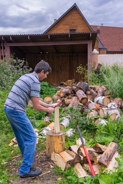 Przystojny Mężczyzna Średnim Wieku Rąbiący Drewno Siekierą Podwórku Wiejskiego Domu — Zdjęcie stockowe