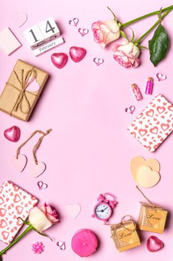 Sevgililer Günün kutlu olsun. Gül çiçeklerinden yapılmış çerçeve, kalpler, hediyeler ve pembe arka planda pembe renkli dekoratif eşyalar. Sevgililer günü için tebrik kartı. Düz konum, üst görünüm, kopyalama alanı.