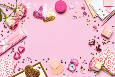 Sevgililer Günün kutlu olsun. Gül çiçeklerinden yapılmış çerçeve, kalpler, hediyeler ve pembe arka planda pembe renkli dekoratif eşyalar. Sevgililer günü için tebrik kartı. Düz konum, üst görünüm, kopyalama alanı.