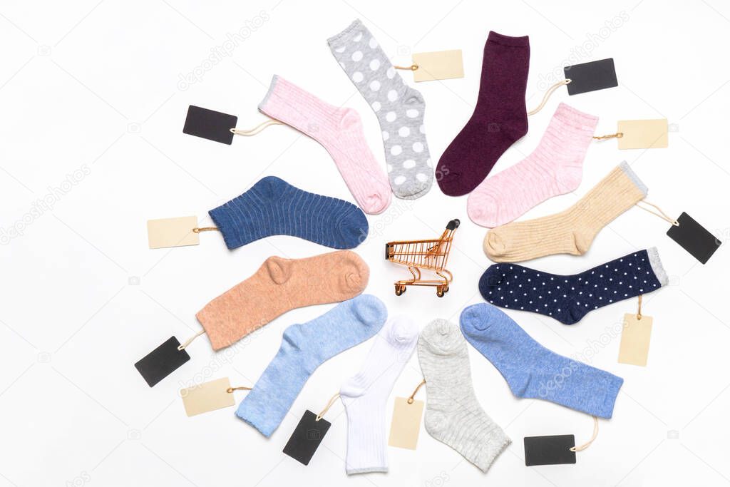Various modern trendy women's cotton socks set with shopping cart and price tags on white background. Fashionable socks store. Socks shopping, sale, merchandise, advertisement concept