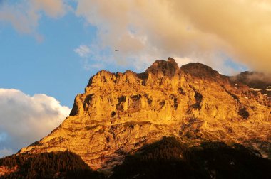 Batan güneşin fotoğrafı İsviçre Alplerinin zirvelerinde parlıyor