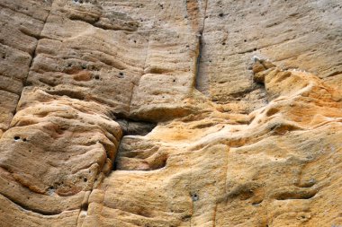 Yıpranmış sarı kaya yüzeyinin fotoğrafı