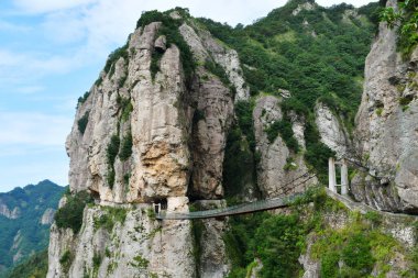 Zhejiang Eyaleti, Çin 'deki bir uçurumun kenarındaki asma köprünün fotoğrafı.