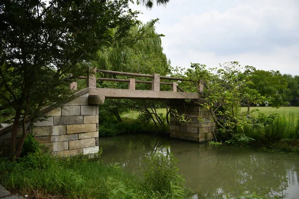 Photo of an old stone bridge over a small river