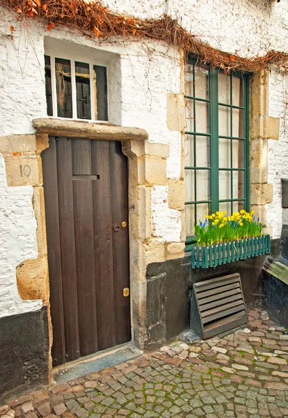 un viejo balcón con unas flores amarillas y blancas — Foto de stock