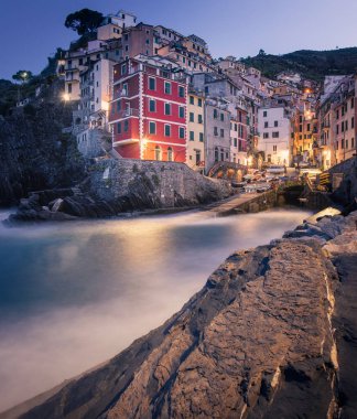 Riomaggiore 'daki Cinque Terre sahili boyunca uzanan renkli evlere bakın.
