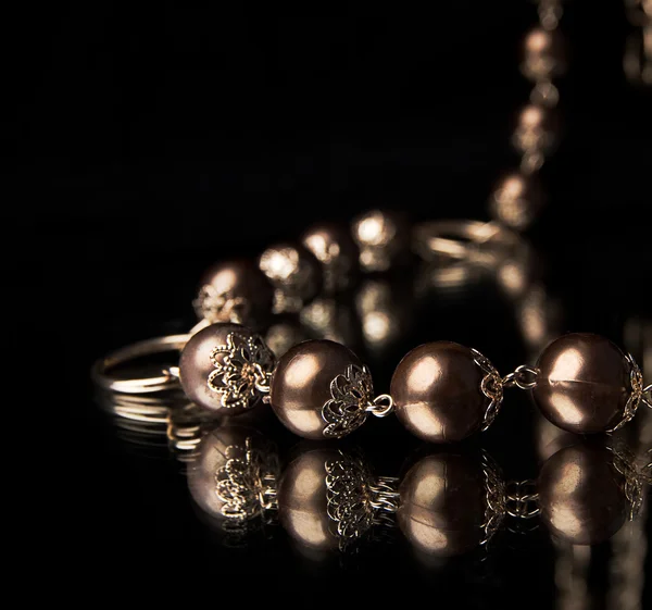 Zlatý náhrdelník nad černou — Stock fotografie