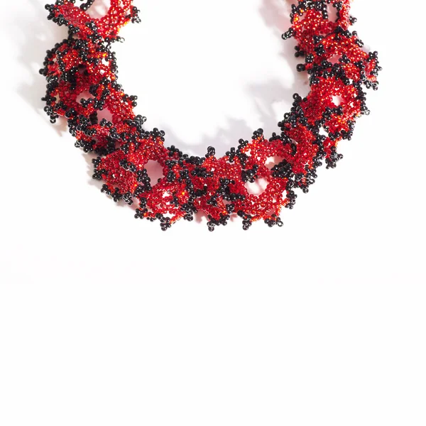Collana di perline rosse e nere su bianco — Foto Stock