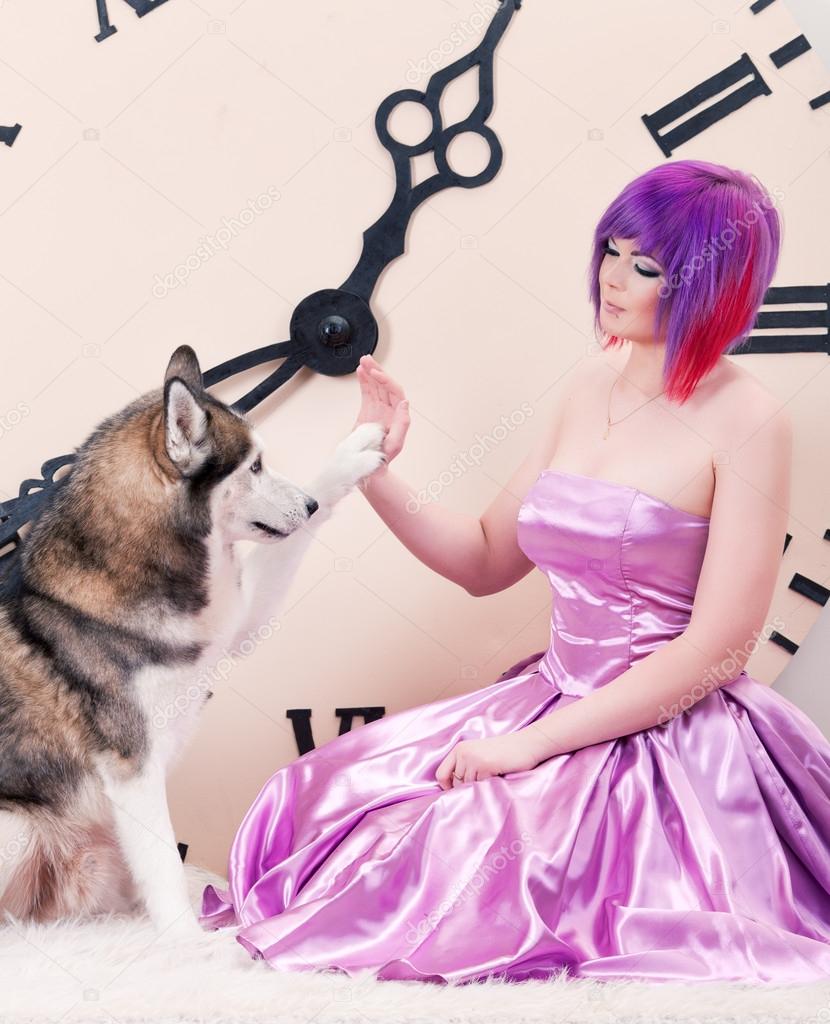 Give me paw. dog giving girl in pink dress a high five