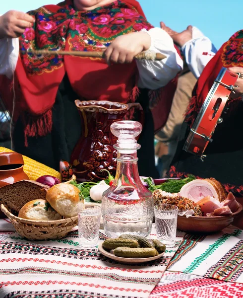 Tabela góry pełne żywności i kobiety w tradycyjnych strojach — Zdjęcie stockowe