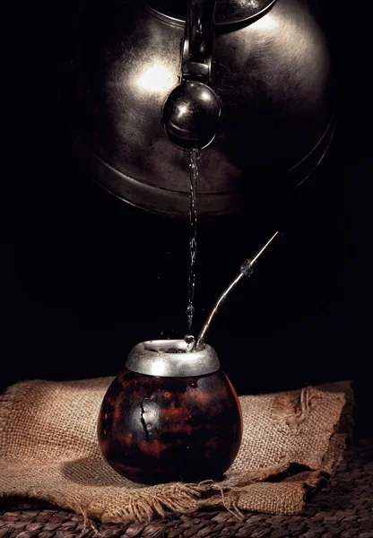 Pouring hot water from kettle into the calabash — Stock Photo, Image