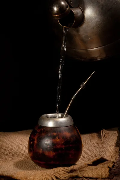 Pouring water from kettle into the calabash — Stock Photo, Image