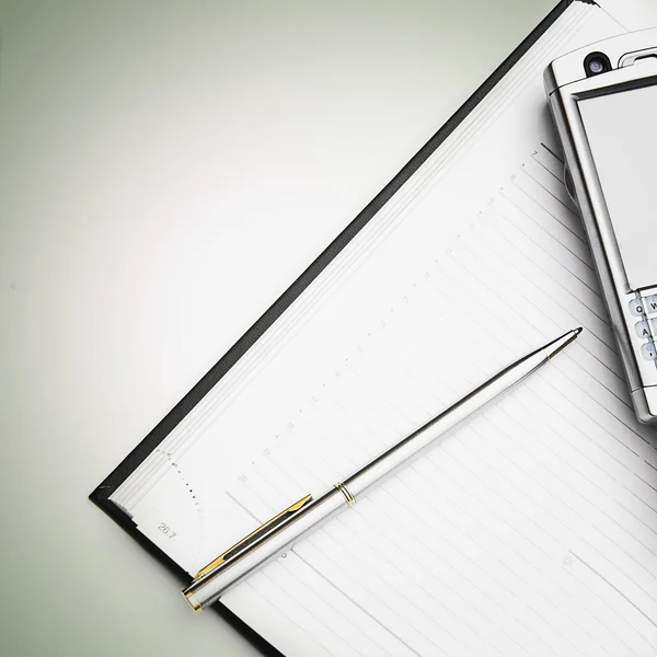 Бизнес планировщик с ручкой и телефоном — стоковое фото