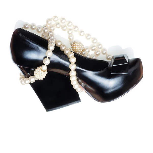 Sapato de mulher negra e colar de pérolas — Fotografia de Stock
