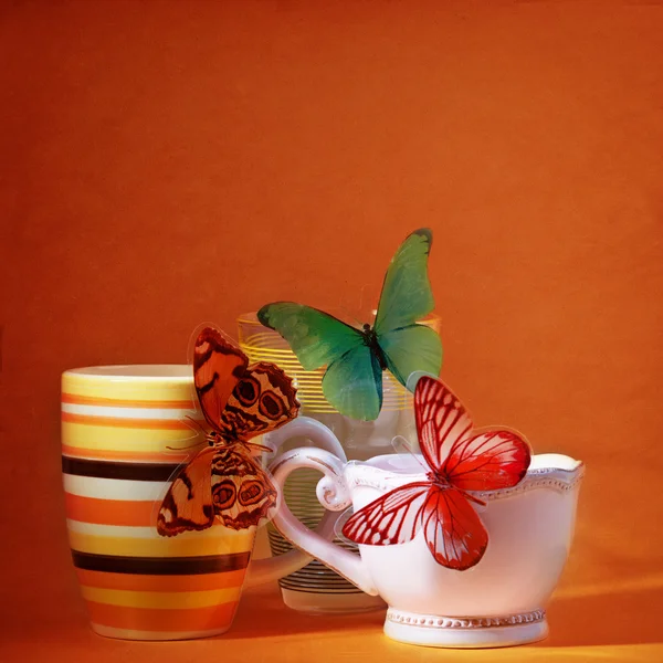 Tasses avec papillon sur fond rouge — Photo