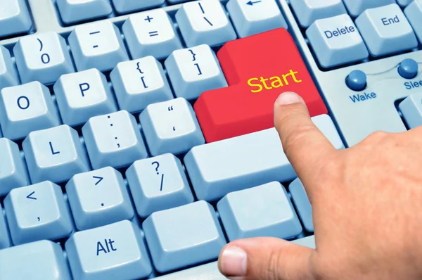 Finger som pekar på den röda nyckeln starten — Stockfoto