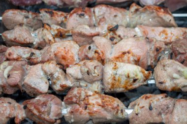 fresh pieces of meat are fried on skewers in the grill