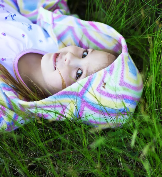 一个年轻的女孩躺在绿草 — 图库照片