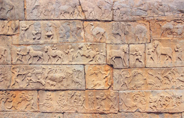 Wall with a carved relief: scenes of hunting and life. India — Stock Photo, Image