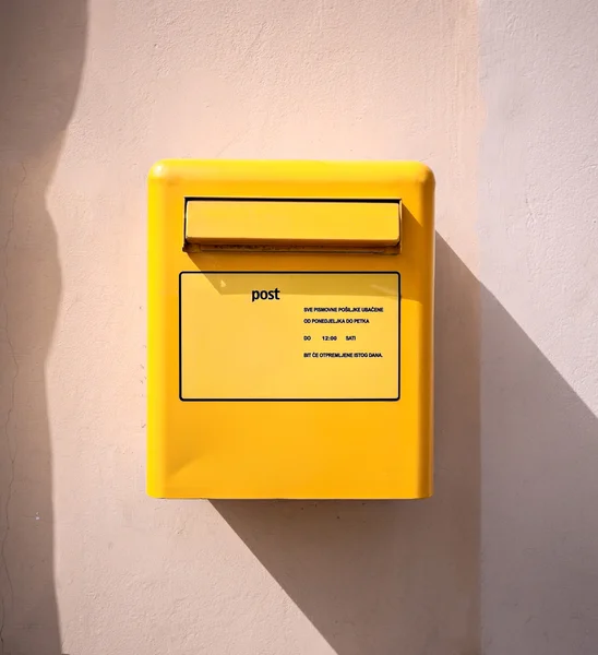 Letter mail delivery post yellow box at wall — Stock Photo, Image