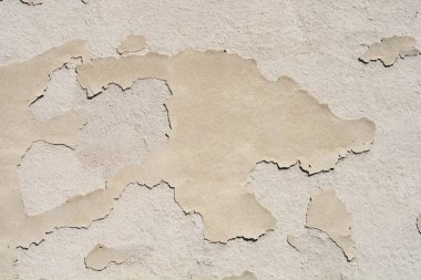 Detail of a beige wall with peeling paint