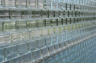 Side view of glass brick wall with reflection in water