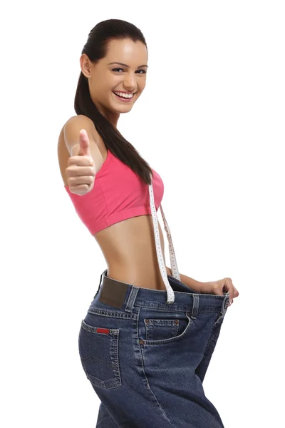 mutlu genç kadın kilo kaybettikten sonra eski kot pantolon