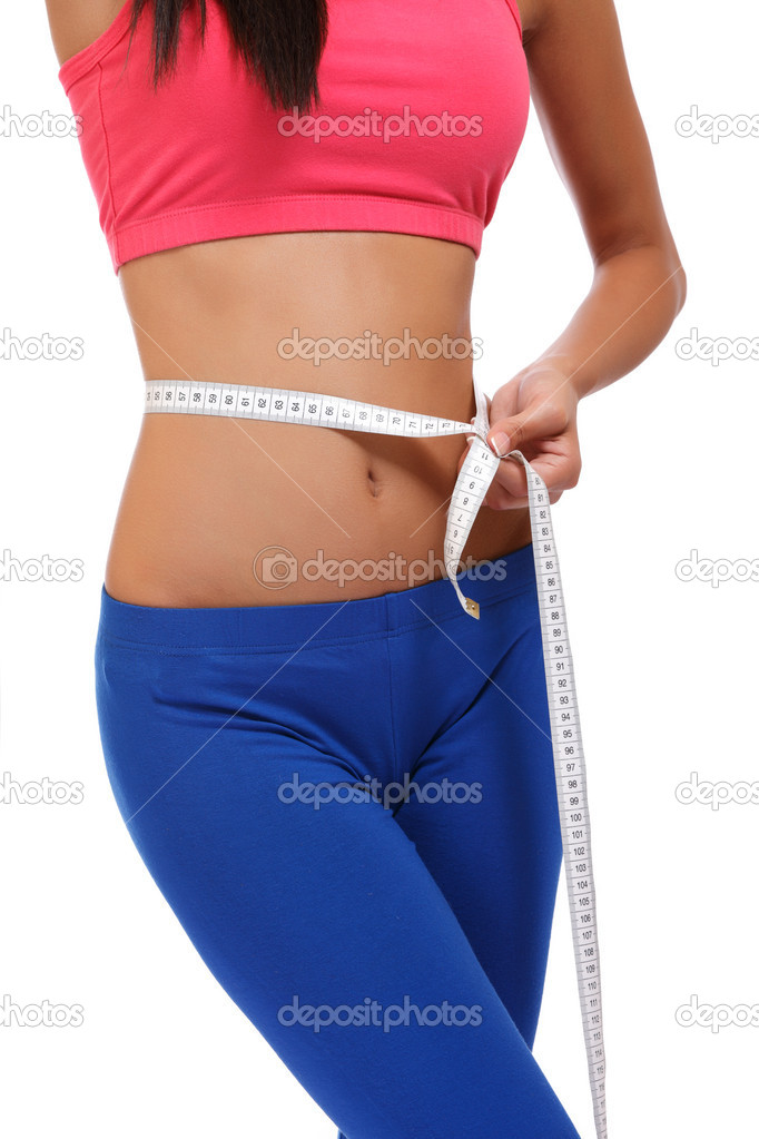 Fit young woman measuring her waistline