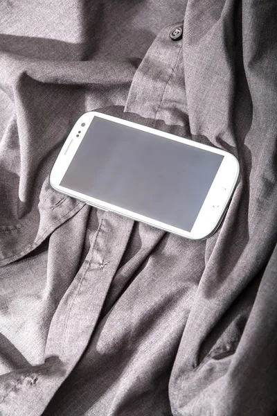 シャツの上のスマートフォン — ストック写真