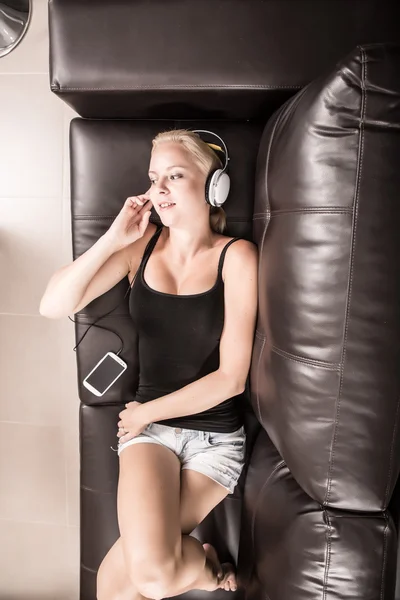 Blond meisje met koptelefoon — Stockfoto