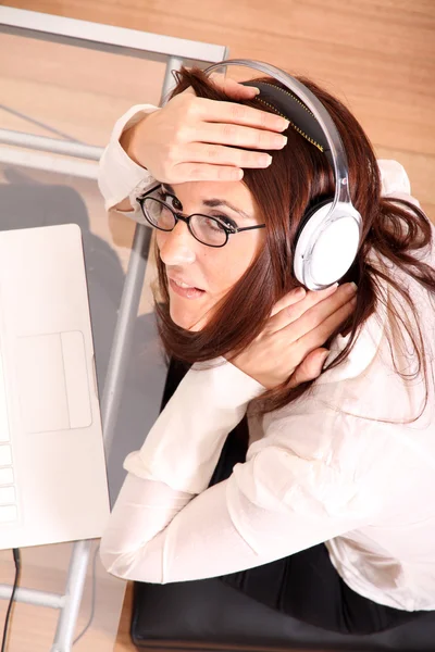 Vrouw met een laptop en hoofdtelefoon — Stockfoto