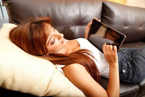 Mit einem Tablet-PC auf dem Sofa — Stockfoto