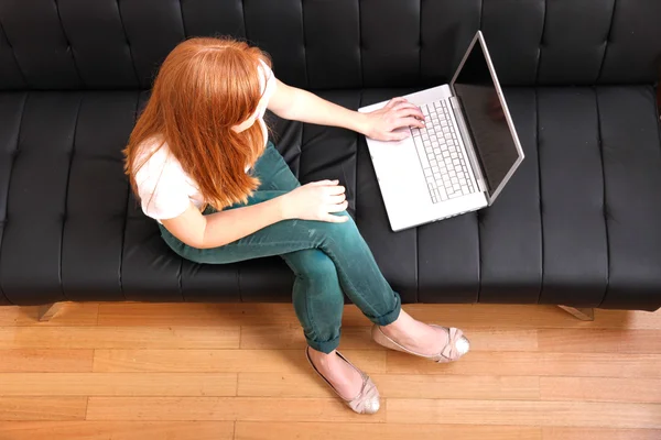 Jonge roodharige meisje met een laptop — Stockfoto