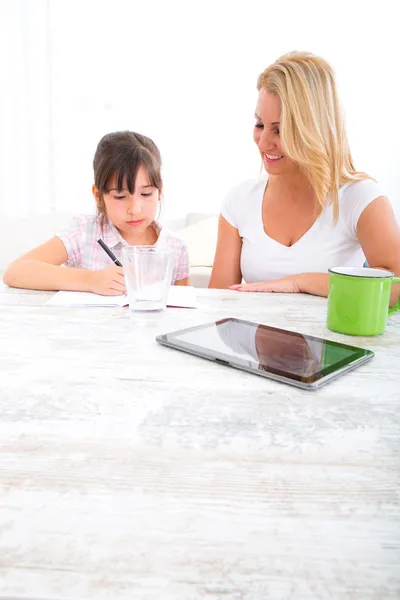 Mamma att hjälpa dottern med läxor — Stockfoto