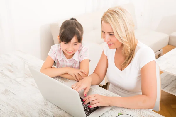 Mère et fille avec un ordinateur portable à la maison — Photo