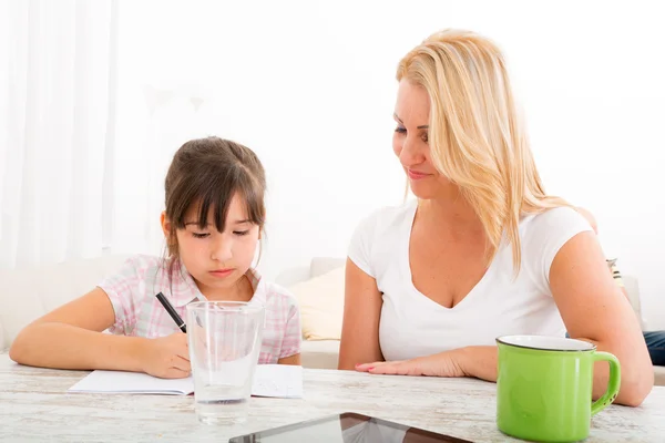 Мама помогает дочери с домашним заданием — стоковое фото