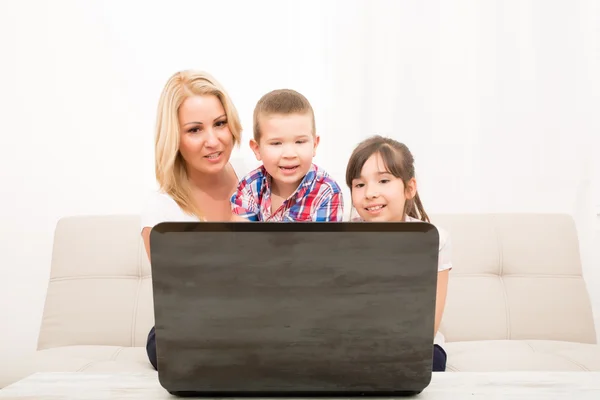 Madre con sus hijos usando una computadora portátil — Foto de Stock