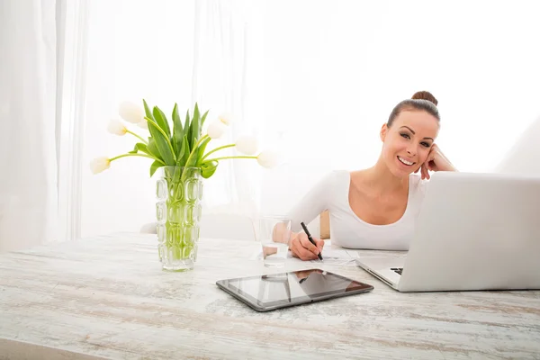 Jonge vrouw die met een laptop werkt — Stockfoto