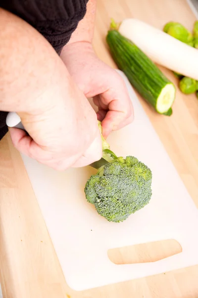 Woman hands cutting broccoli — Stock Photo, Image