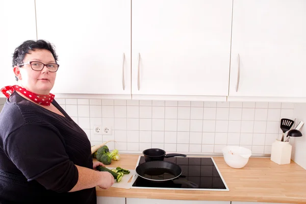 Woman cutting and frying cucumber — Stock Photo, Image